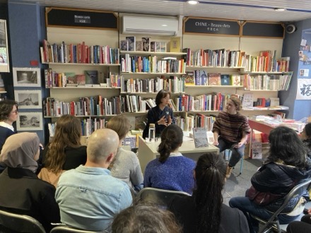 Yong Hee Cho en rencontre publique dans une librairie, devant le rayon Asie.