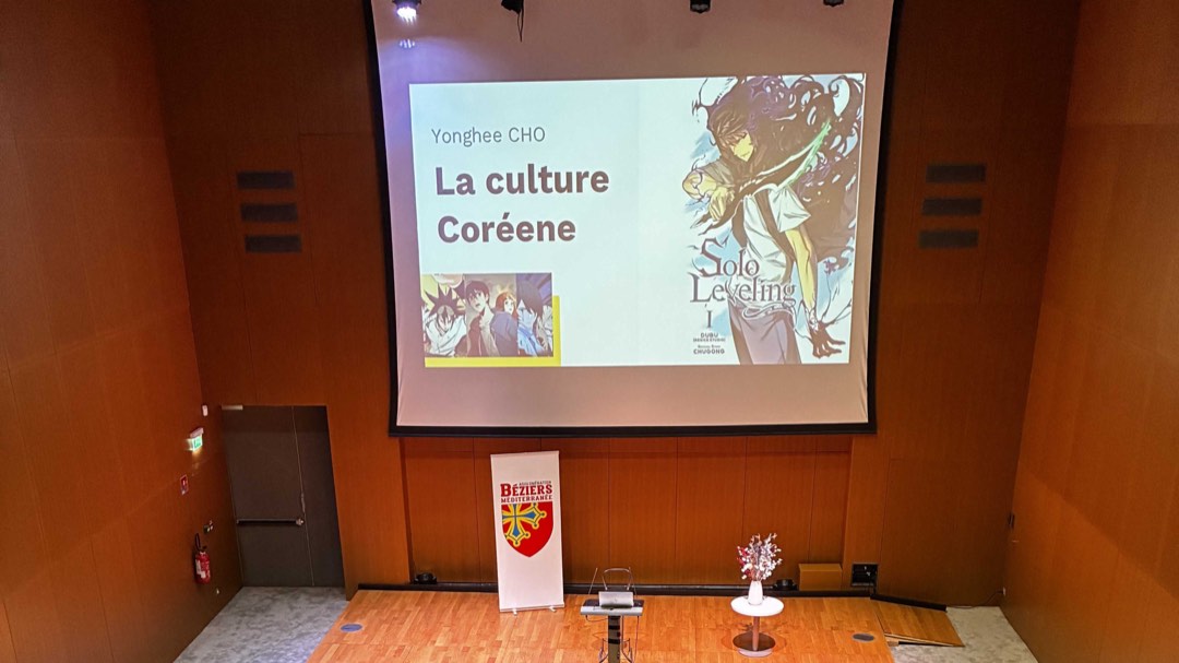 Écran de conférence « La culture coréenne » par Yonghee Cho, sur la scène de l’Agglomération Béziers Méditerranée.